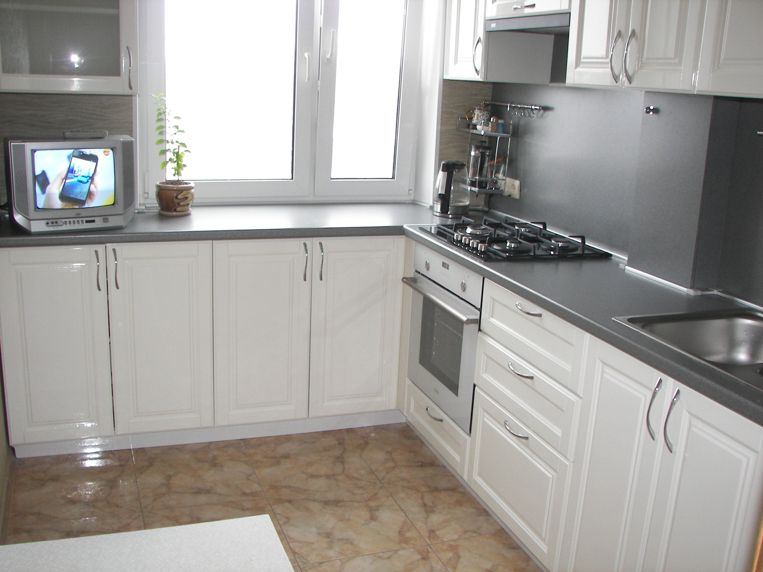Белая угловая кухня с серой столешницей